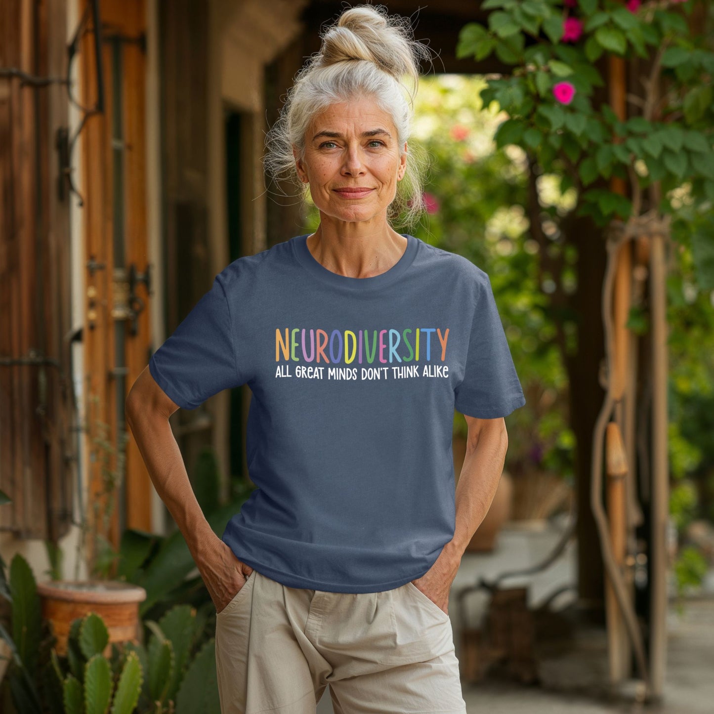 Woman wearing a blue t-shirt with 'NEURODIVERSITY ALL GREAT MINDS DON'T THINK ALIKE' text outdoors.