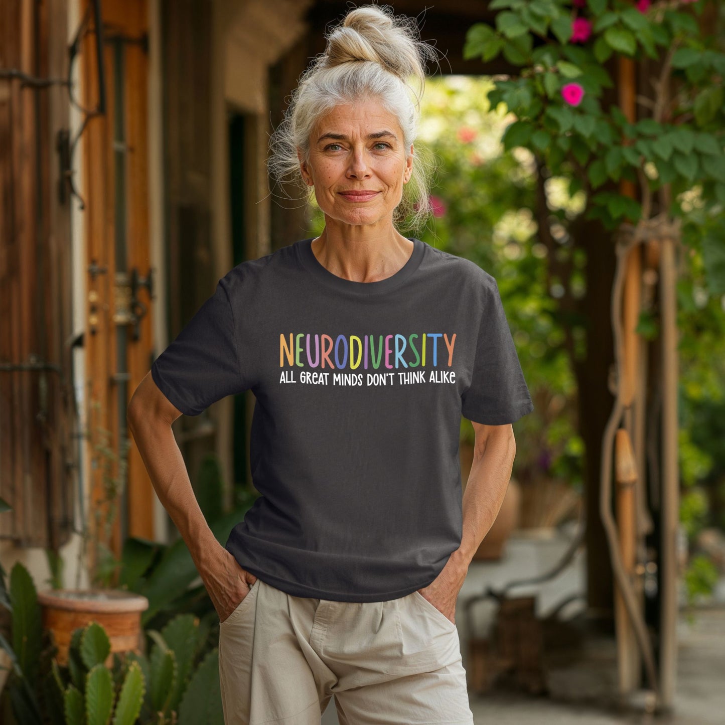 Woman wearing a black t-shirt with 'NEURODIVERSITY ALL GREAT MINDS DON'T THINK ALIKE' text outdoors.