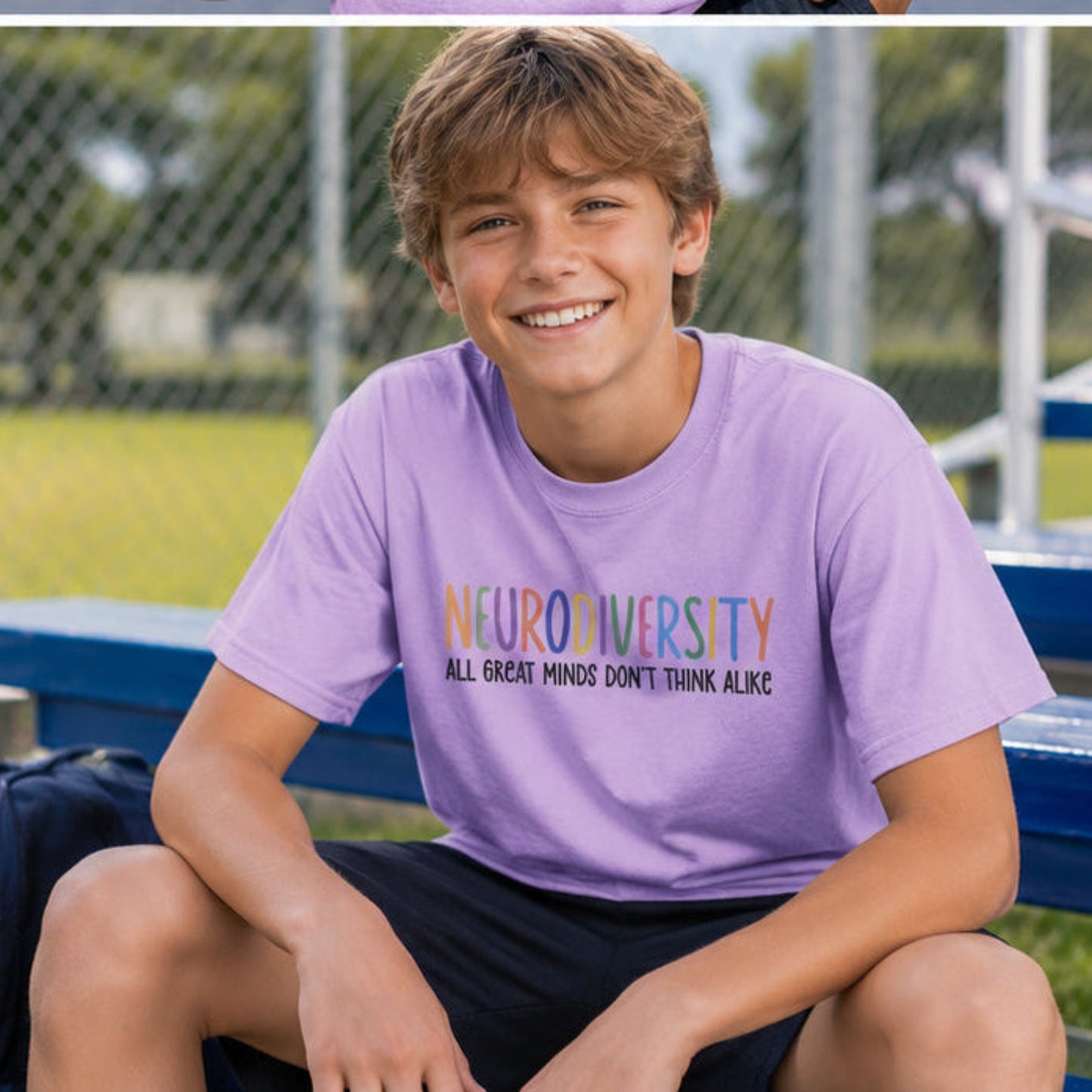 A smiling young man sits on blue stadium bleachers outdoors wearing a lavender graphic T-shirt that reads 'NEURODIVERSITY ALL GREATEST MINDS DON'T THINK ALONE.' A dark backpack and water bottle sit beside him, with a chain-link fence and grassy field in the background.